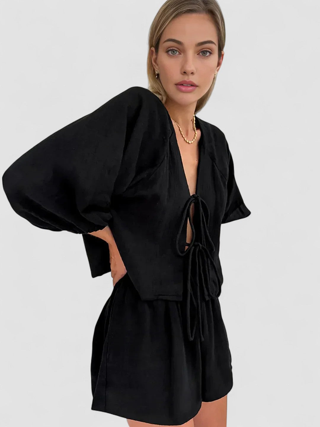 Black long-sleeve blouse and short set with bow-tie neckline and puff sleeves
