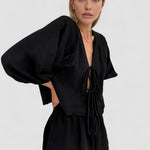 Black long-sleeve blouse and short set with bow-tie neckline and puff sleeves