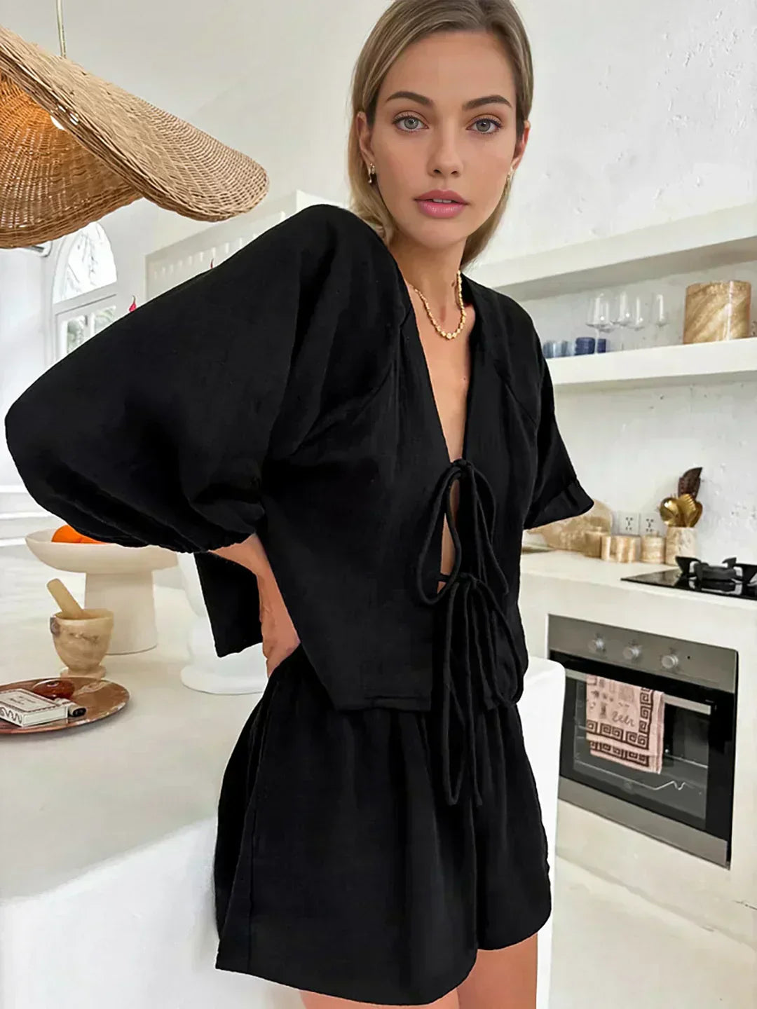 Black long-sleeve blouse and short set with drawstring bow detail at neckline