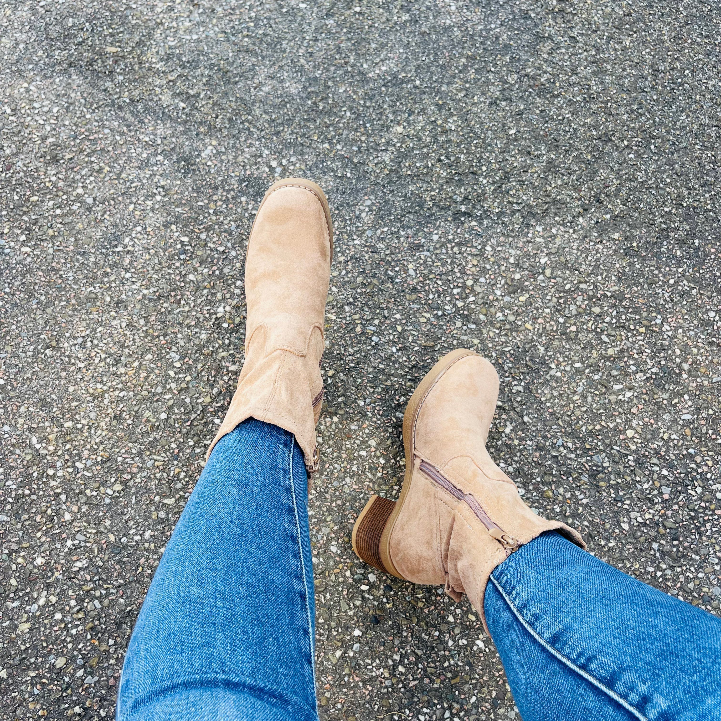 Beige suede ankle boots with low stacked heel, worn with blue jeans