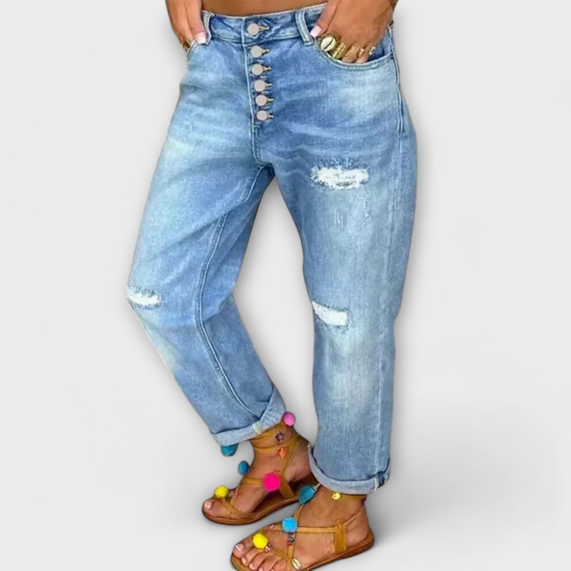 Light blue denim jeans with button fly and knee rips