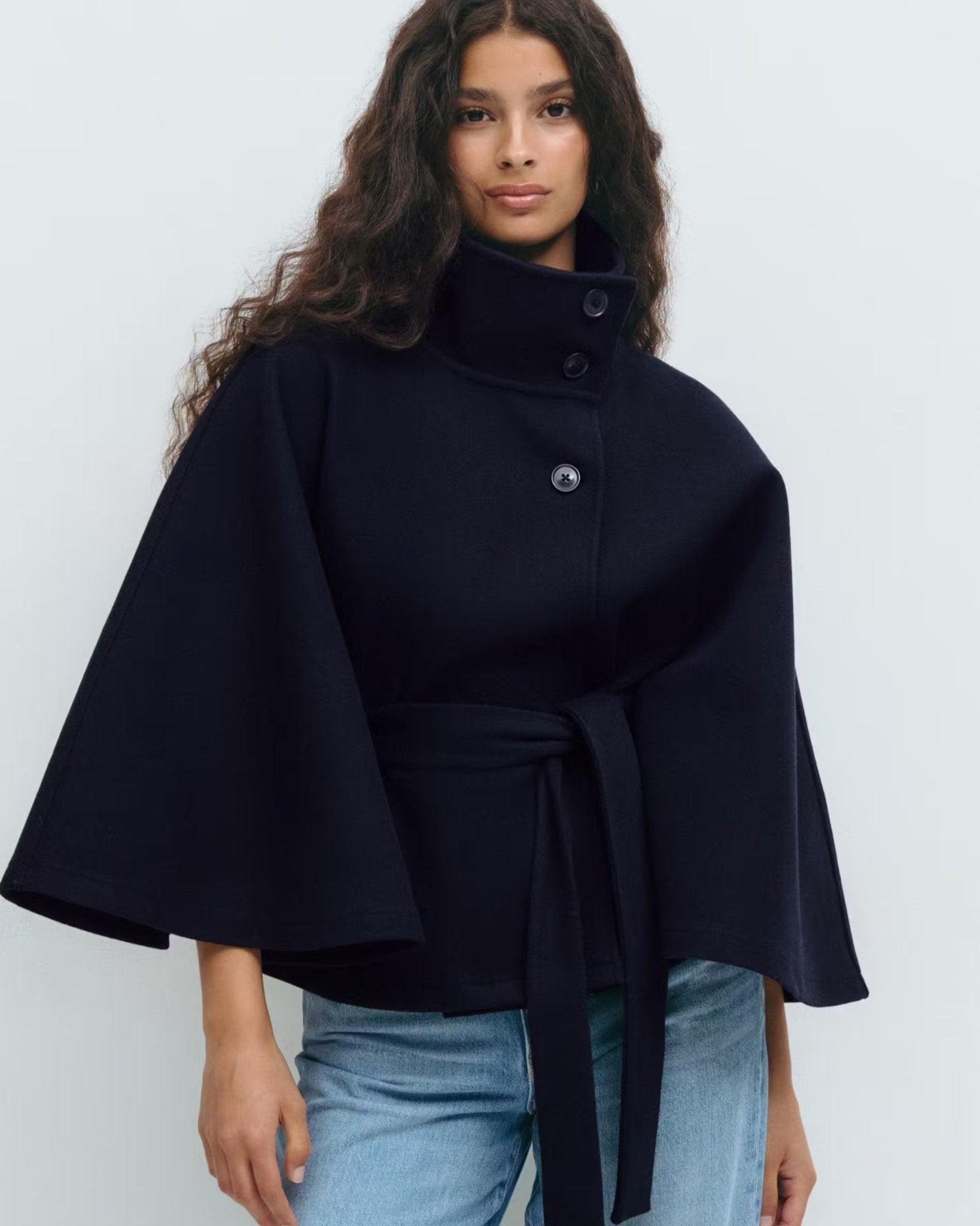 Navy belted jacket with high neck and button front, cape sleeves