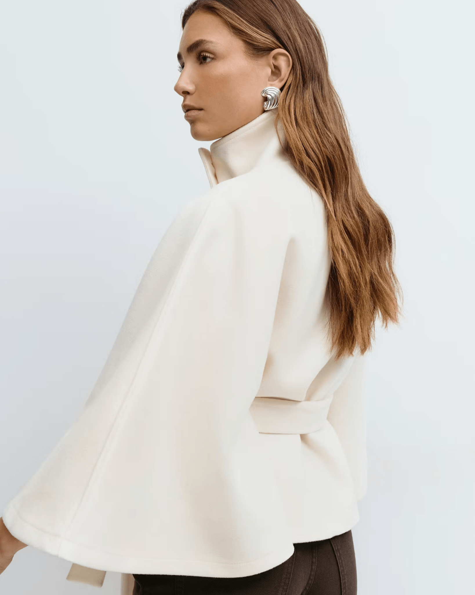 White belted jacket with high collar, button front, cape sleeves