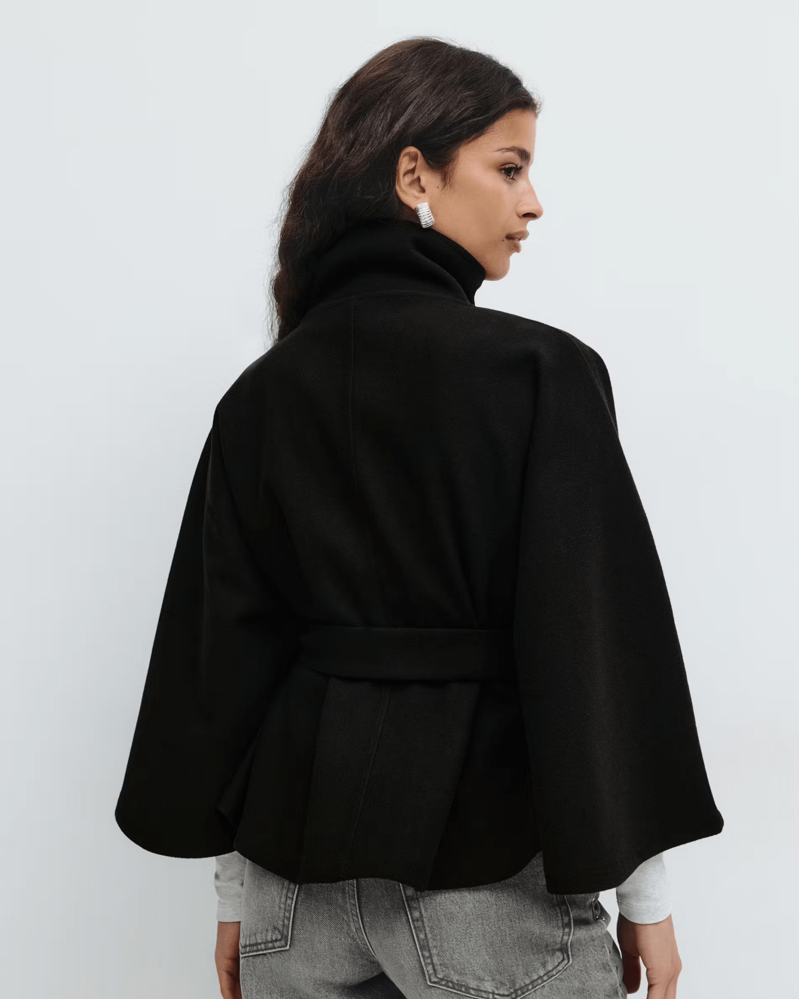 Black belted jacket back view with high neck and button front