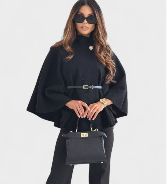 Black cape-style coat with high neck, round buttons, and gold-buckle waist belt