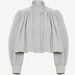 Light gray short loose jacket with pleated yoke, button front, and voluminous sleeves