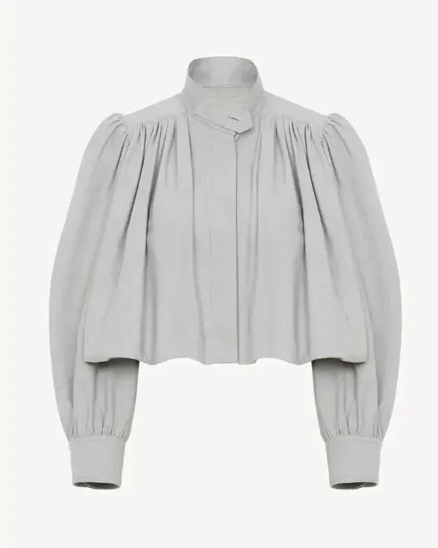 Light gray short loose jacket with pleated yoke, button front, and voluminous sleeves