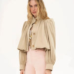 Cream cropped blouse jacket with gold buttons, high neck, and puffed sleeves