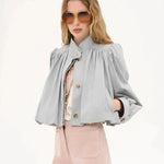 Light gray short loose jacket with button placket, pleated shoulders, and puff sleeves