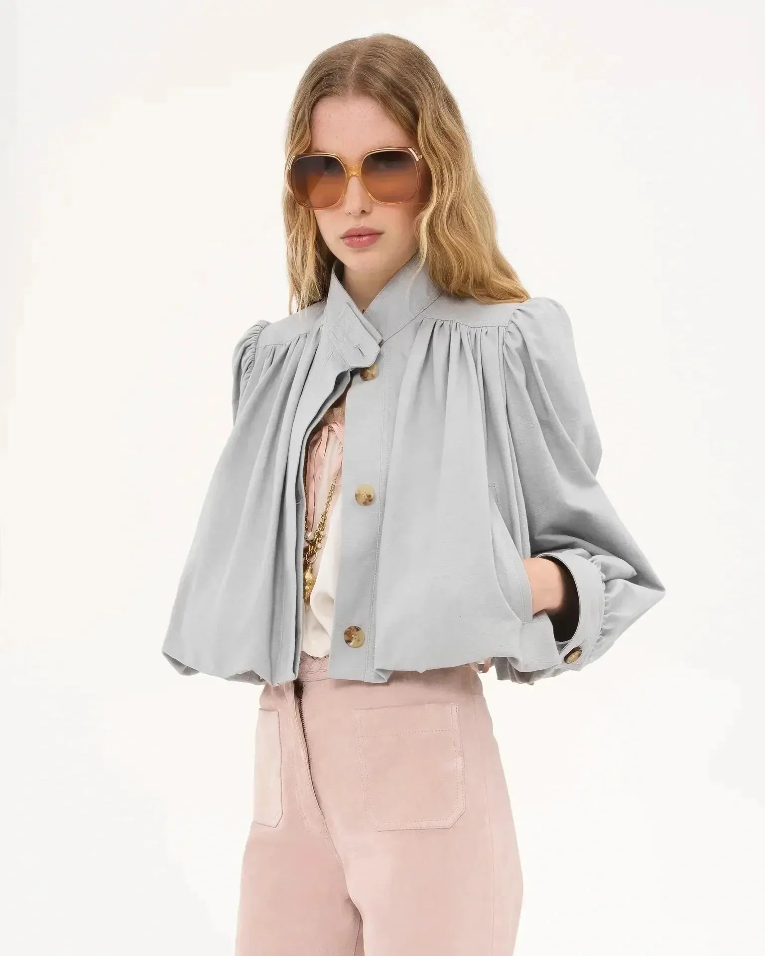 Light gray short loose jacket with button placket, pleated shoulders, and puff sleeves