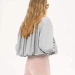 Light gray cropped jacket back view with pleated yoke and balloon-style sleeves