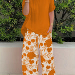 Isolde two-piece set: orange blouse with short sleeves and orange floral wide-leg pants
