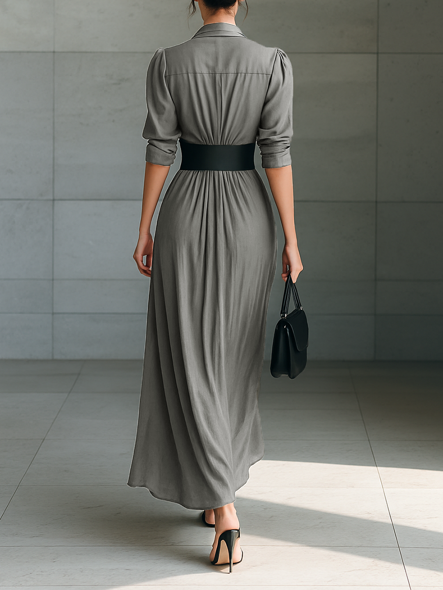 Back view of long pleated grey dress with belted waist and three-quarter sleeves
