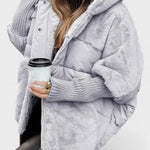 Light gray hooded puffer jacket with sherpa lining and zipper front