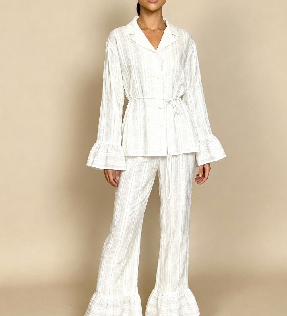White long-sleeve pajama set with button-up top and wide-leg pants, tie waist