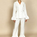 White long-sleeve pajama set with button-up top and wide-leg pants, tie waist