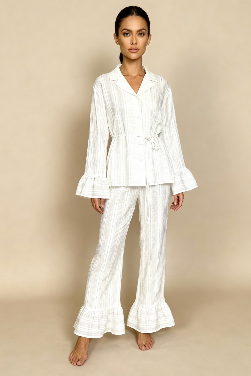 White long-sleeve pajama set with button-up top and wide-leg pants, tie waist