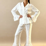 White pajama set with button-up top, tie waist, and wide-leg pants