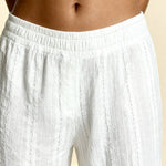 White pajama pants with elastic waist and vertical textured stripes