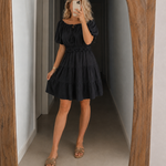 Black off-shoulder tiered mini dress with puff sleeves and smocked waist
