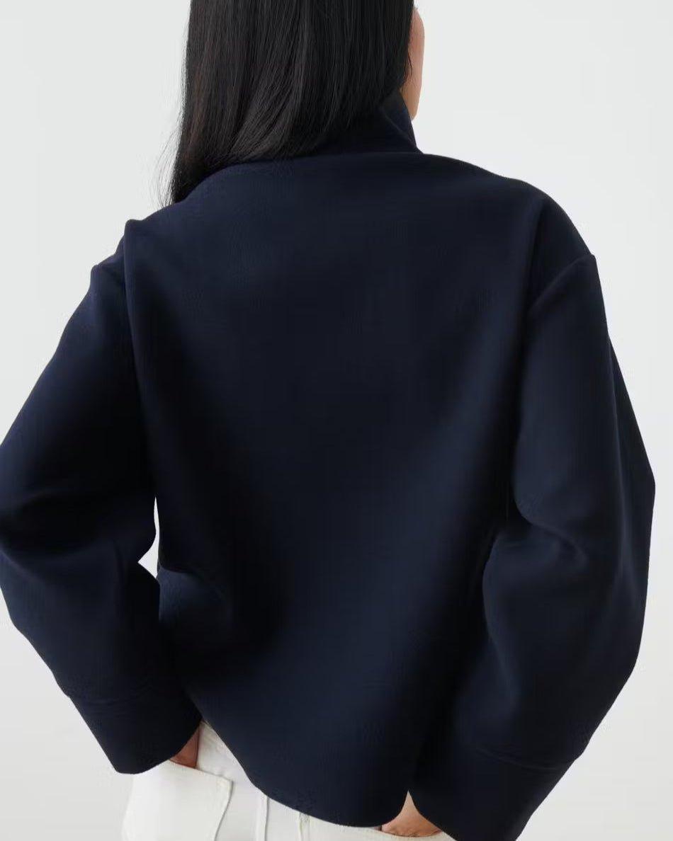 Back view of dark navy cropped jacket with buttoned shoulder detail