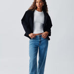 Cropped dark navy jacket with high collar and concealed button front