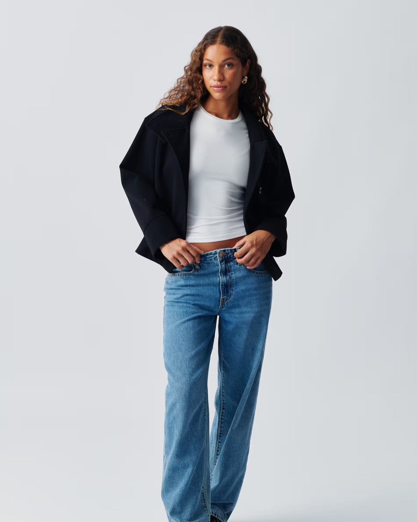 Cropped dark navy jacket with high collar and concealed button front