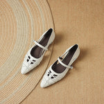 Pair of cream Mary Jane flats with ankle strap, cutout lattice sides, pointed toe