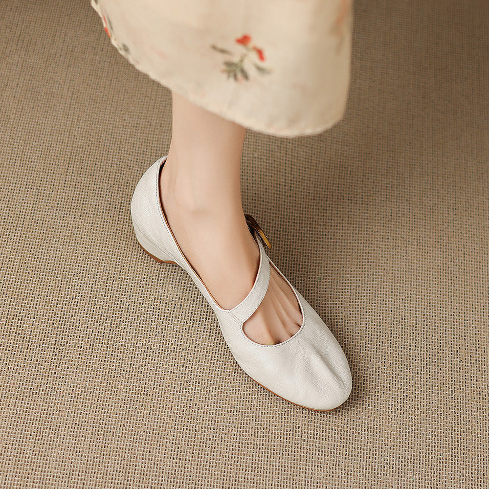 Light cream Mary Jane shoes with round toe and buckle strap, angled view