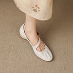 Light cream Mary Jane shoes with round toe and buckle strap, angled view