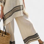Beige tunic top and wide-leg pants with black striped cuffs and hem