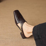 Dark brown leather mule loafers with open toe and patterned strap trim