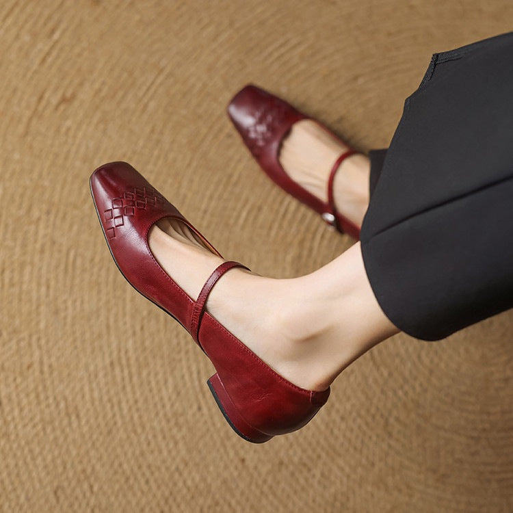 Red Mary Jane flats with square toe, woven strap detail, low heel.