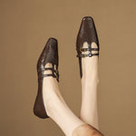 Brown Mary Jane flats with double strap buckle detail and perforated toe