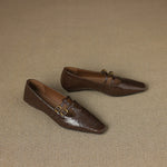 Brown perforated Mary Jane flats with two buckle straps, closed toe design