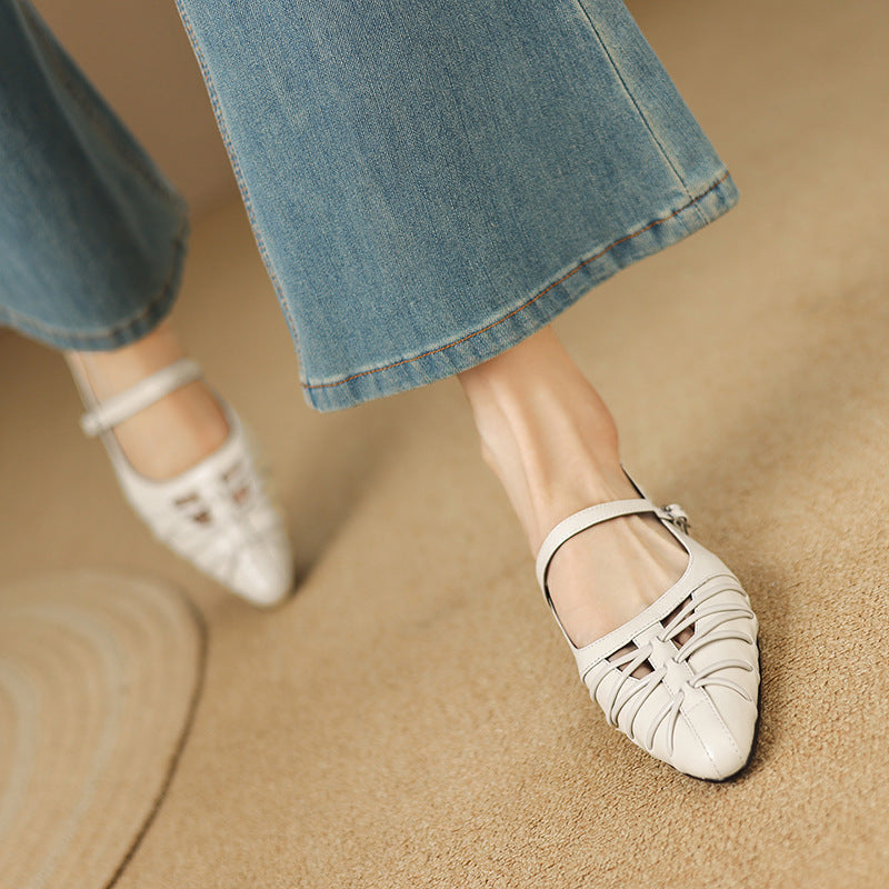 Cream Mary Jane flats with ankle strap and pointed toe; worn with blue jeans