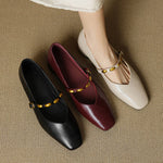 Leather ballet flats in black, burgundy, and cream with gold buckle straps