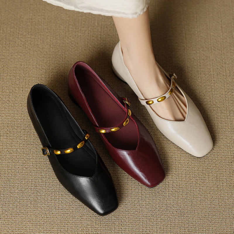 Leather ballet flats in black, burgundy, and cream with gold buckle straps