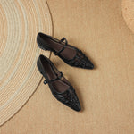 Black Mary Jane flats with ankle strap and crisscross detail; pair view
