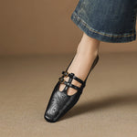 Black Mary Jane flats with two buckle straps and perforated toe details