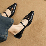 Black Mary Jane flats with ankle strap, pointed toe, and crisscross cutouts