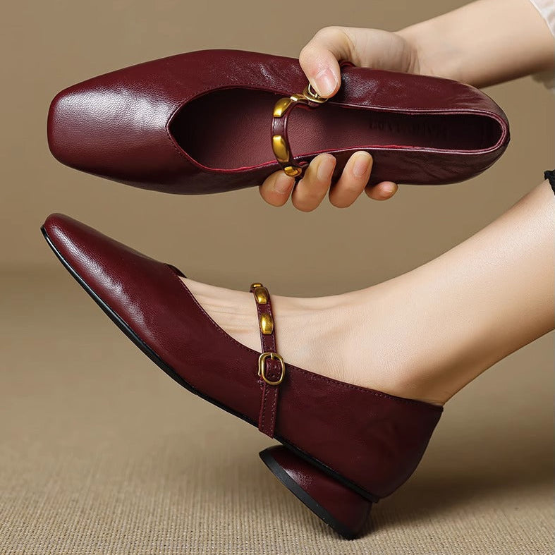 Burgundy leather ballet flats with gold buckle strap and low block heel, close-up