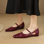 Burgundy Mary Jane flats with ankle strap and buckle, laced upper and low profile sole.