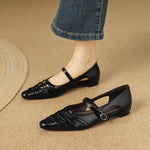 Black Mary Jane flats with ankle strap and buckle, laced upper, pointed toe.