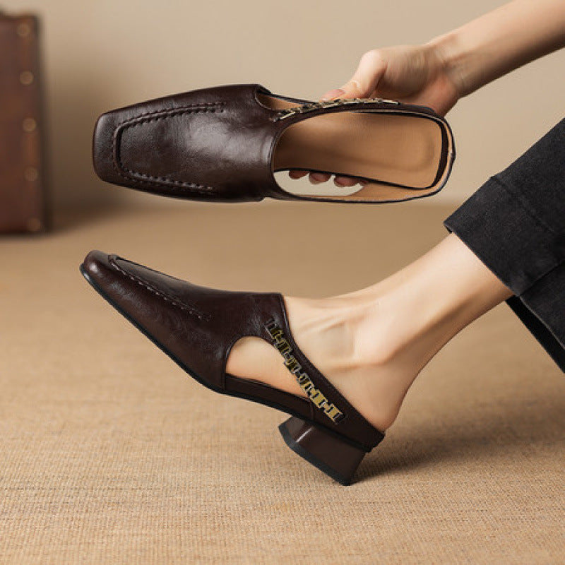 Dark brown leather mule loafers with side cutout and decorative strap detail