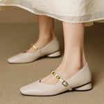 Beige leather ballet flats with gold buckle strap and stud trim