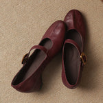 Pair of burgundy round-toe Mary Jane pumps with buckled straps and low block heel