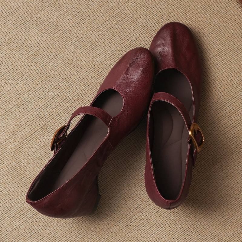 Pair of burgundy round-toe Mary Jane pumps with buckled straps and low block heel