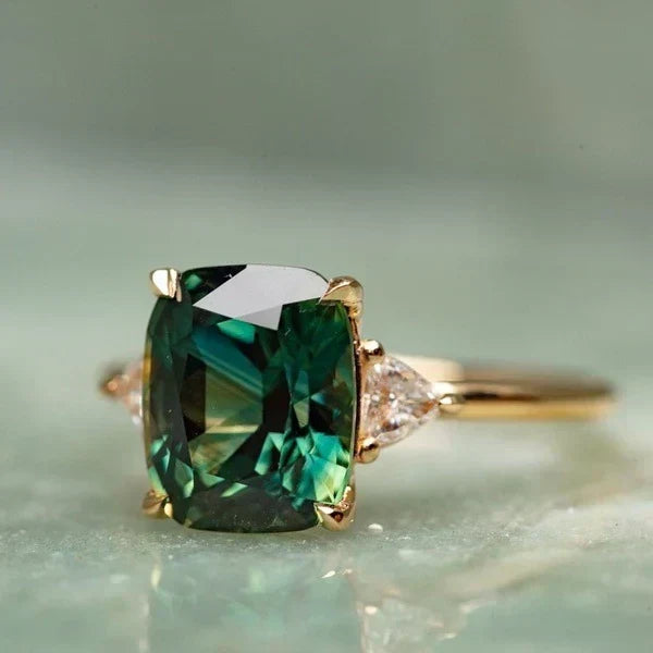 Vintage gold ring with emerald-cut dark green gemstone and small side diamonds