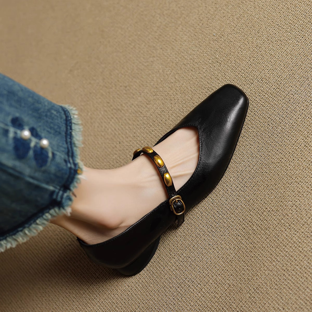 Black leather ballet flat with gold buckle strap and round toe